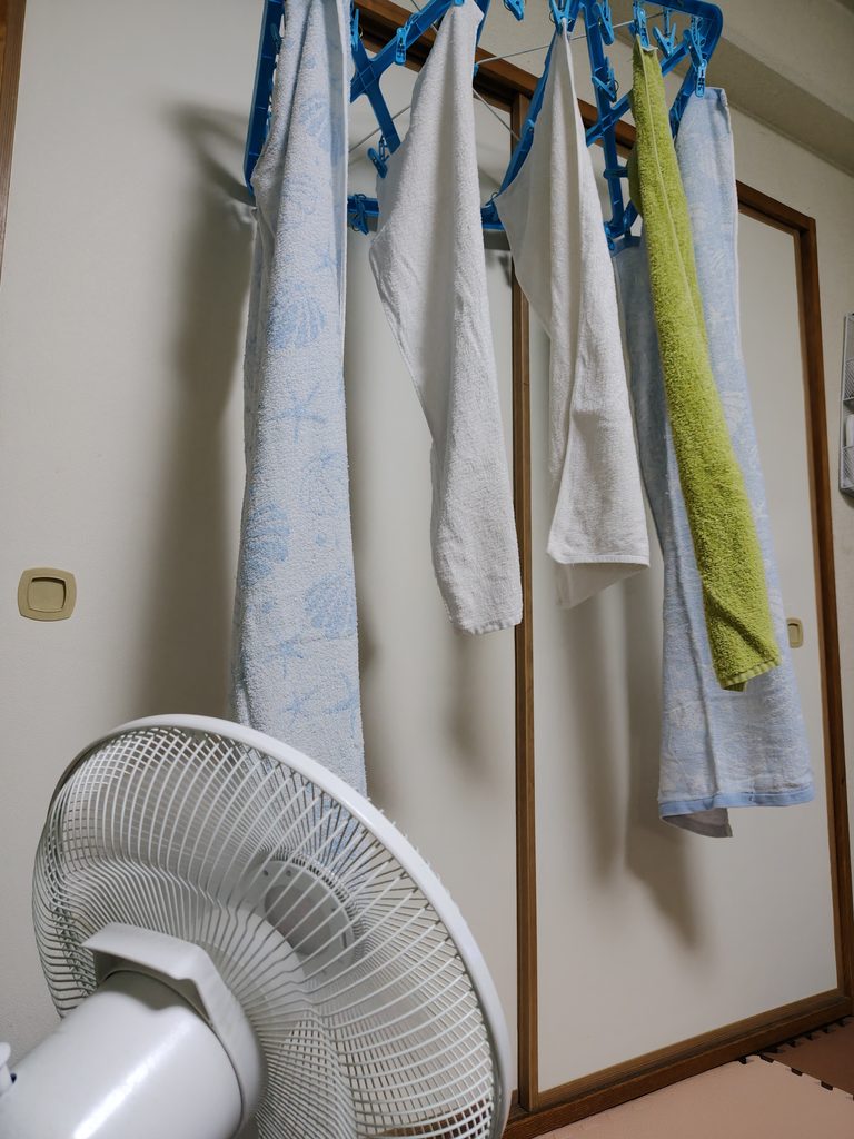 部屋干しの洗濯物にサーキュレーターの風を当てる様子