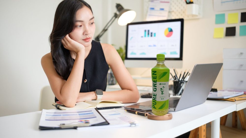 仕事のリフレッシュにピュアグリーンを飲む女性の写真